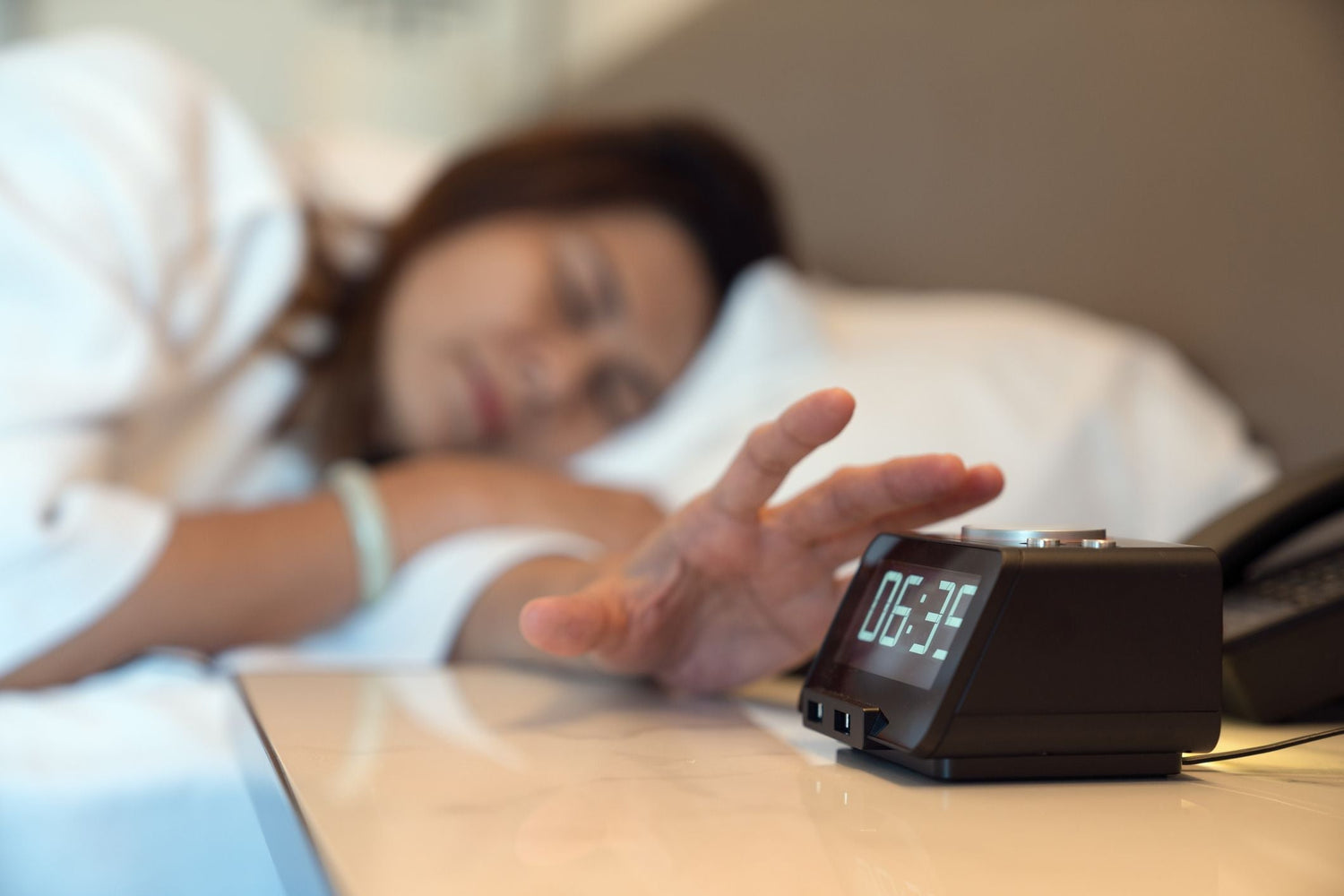 alarm-clock-for-deaf-people-woman-pressing-the-stop-button-on-her-
