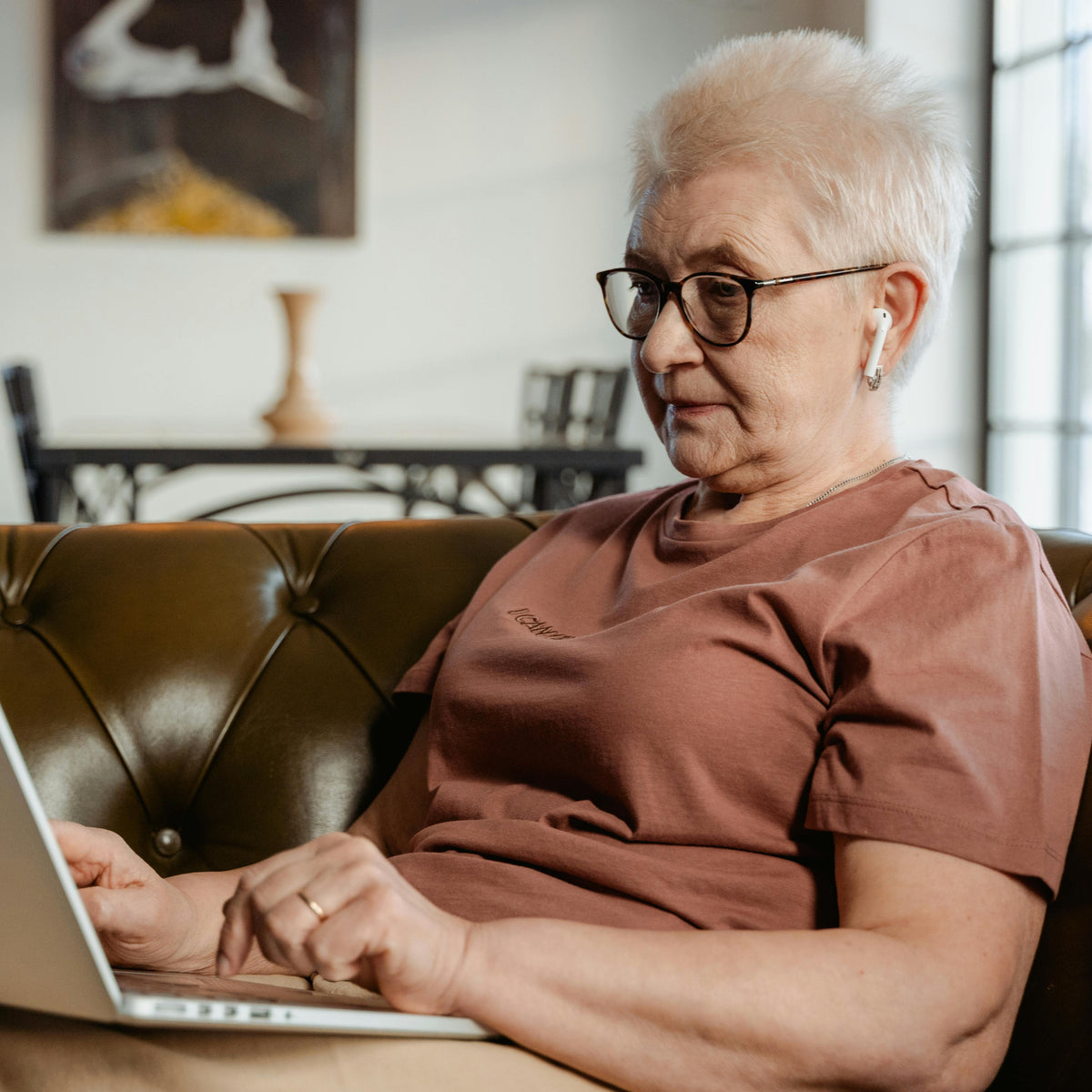 senior citizen using hearing aid and reading glasses